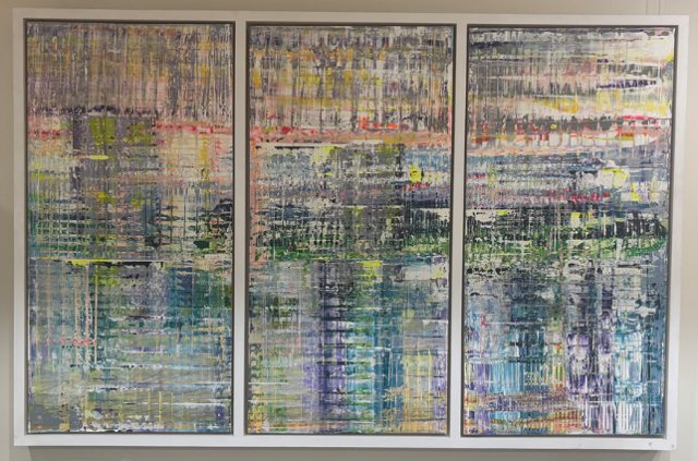 A framed three-panel painting installed on a corridor wall