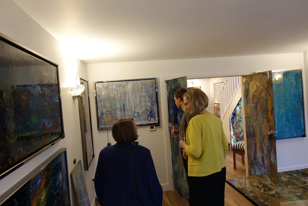 Guests moving between rooms hung with paintings