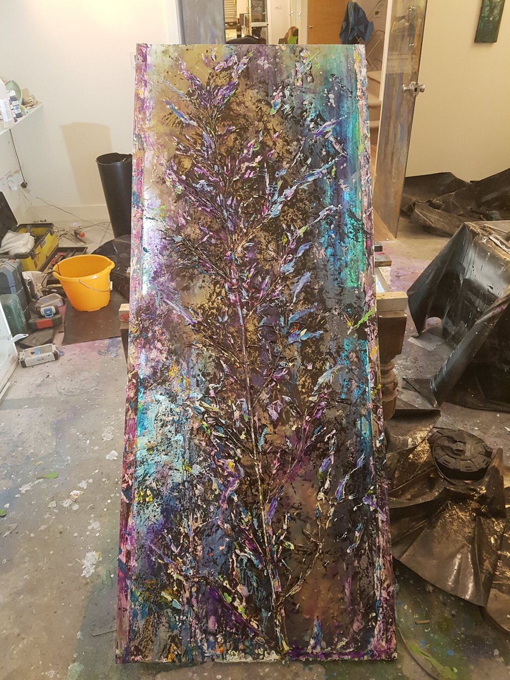 Tall mixed-media glass panel in the studio, layered inks and resin, made to be backlit