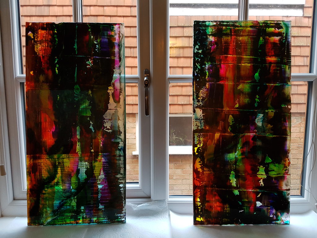 Painted glass panels glowing against a window, backlit by daylight